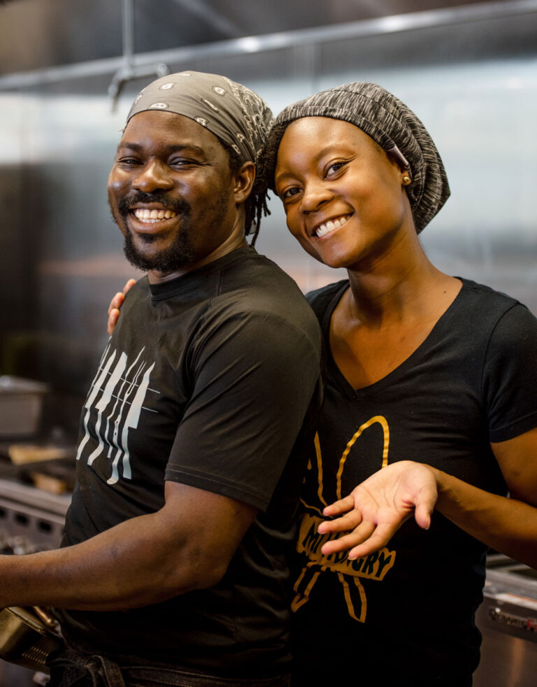 Young Black man and woman smiling in a kitchen